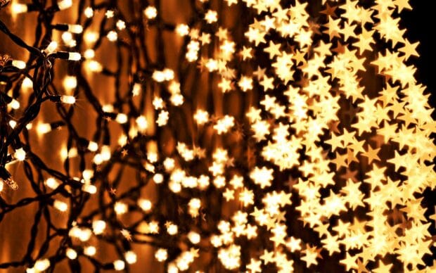 Golden star shaped lights creating a beautiful bokeh effect with dark wires visible