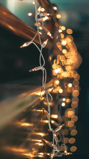 Close up of gold lights hanging on a wall creating a warm glow effect