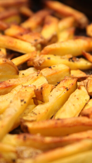 A close up of golden crispy French fries sprinkled with herbs and seasoning, HD Phone Wallpaper