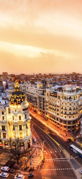 The golden hour cityscape in Spain shows historic buildings and empty streets at sunset, 2K Mobile Wallpaper