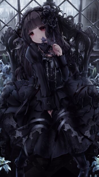 Gothic girl in dark lace dress holding a flower in a dimly lit room