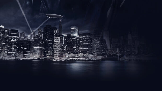 Gotham skyline with illuminated buildings and a blimp flying over the city at night