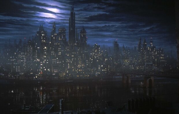 Gotham skyline showing a dark cityscape under a cloudy night sky with illuminated windows