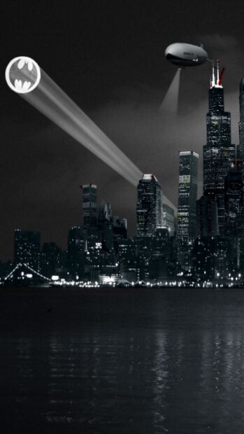 Gotham city skyline at night with a bat signal projected into the sky