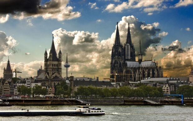 Một nhà thờ Gothic cao chót vót trên đường chân trời của thành phố với những đám mây ấn tượng, Hình nền máy tính 2K