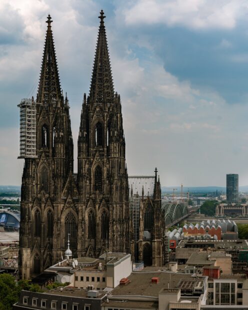 Một nhà thờ gothic với những ngọn tháp cao chót vót nổi bật trên cảnh quan thành phố dưới bầu trời nhiều mây, Hình nền máy tính HD