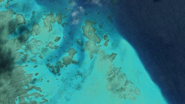 Aerial view of the Great Barrier Reef showing vibrant turquoise and deep blue waters