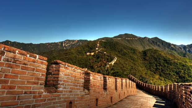The Great Wall of China stretching over green hills under a clear blue sky
