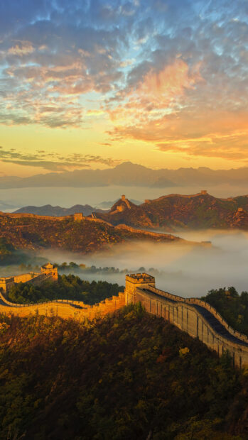 The Great Wall Of China stretching over misty mountains during a golden sunrise