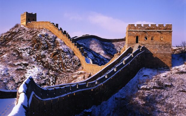 The Great Wall Of China stretches across snowy mountains in a scenic winter landscape