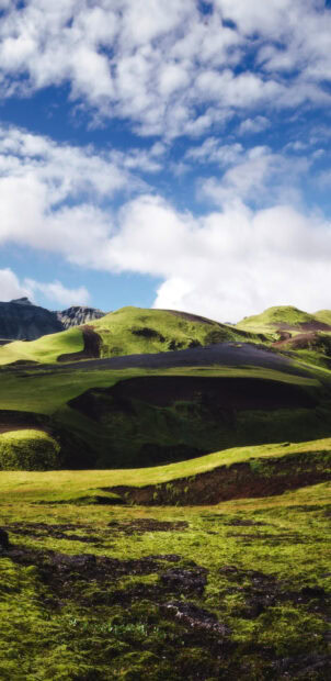 A peaceful landscape of green hills under a bright blue sky with clouds, 2K Phone Wallpaper