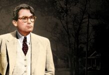 Colorful vintage film character wearing glasses and beige suit standing outdoors at dusk.