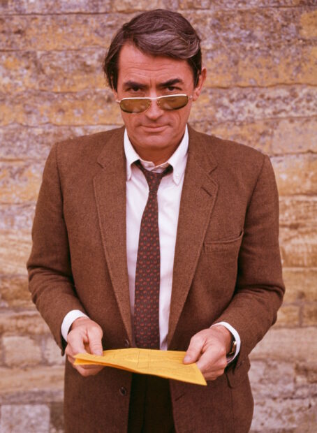 Gregory Peck is wearing a brown suit and sunglasses while holding a yellow paper, 2K Mobile Wallpaper