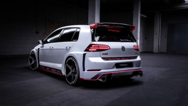White modified Gti car parked in dark garage with sporty decals and red accents