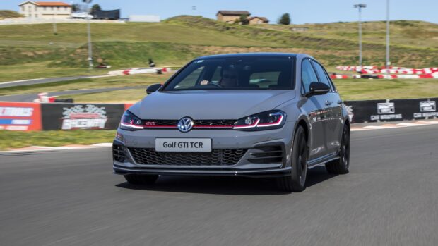 Gray Volkswagen Golf GTI driving fast on raceway track
