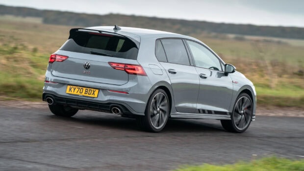 Grey Volkswagen Gti driving on a country road with a blurred background