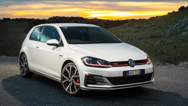 White Gti parked on road during sunset with hills in the background