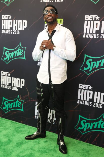 Gucci Mane wearing a white shirt and black pants posing at the BET Hip Hop Awards event