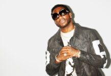 Gucci Mane wearing sunglasses and a leather jacket posing against a white background