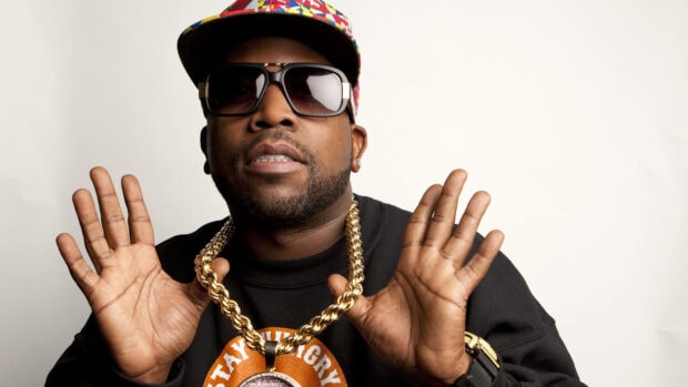Gucci Mane wearing sunglasses and a colorful cap with a gold chain necklace
