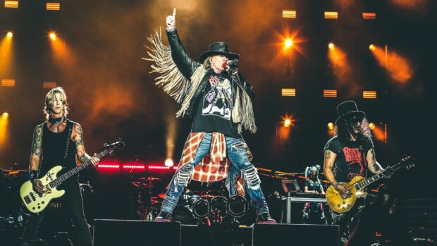 Guns N Roses performing live on stage with vibrant lights and dynamic energy
