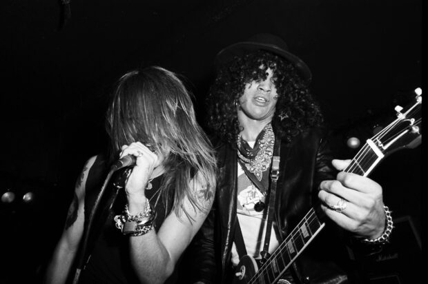 The Guns N Roses band members perform energetically on stage during a live rock concert