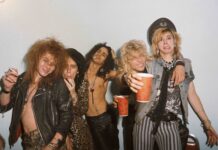 Guns N Roses band members posing together in a casual setting with cigarettes and drinks