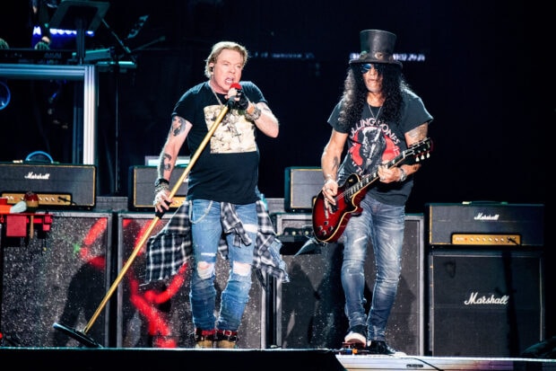 Guns N Roses band performing live on stage with singer and guitarist in concert setting