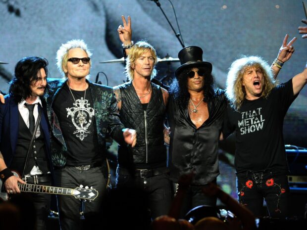 Guns N Roses band members standing together on stage after a concert event