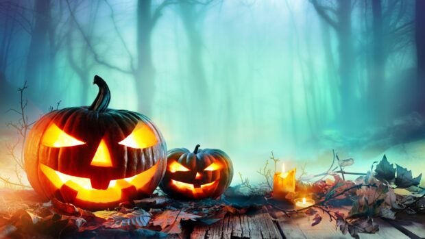 Two glowing pumpkins light a spooky forest scene with candles, 2K Desktop Wallpaper