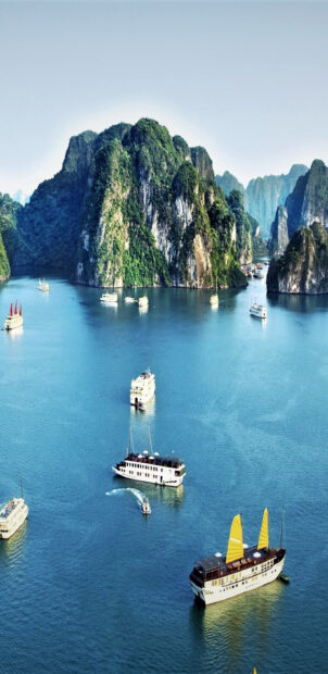 Traditional boats sailing near limestone islands in Halong Bay