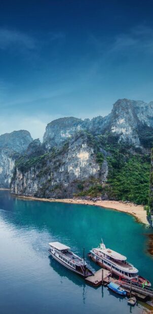 A scenic view of Halong Bay with limestone karsts and boats docked at the pier