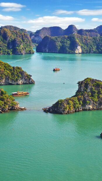 Scenic Halong Bay with green limestone islands and boats on turquoise water