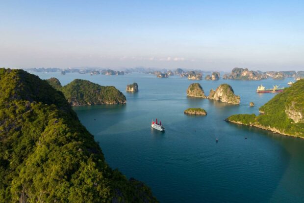 A scenic view of Halong Bay islands with lush greenery and calm blue waters under a clear sky
