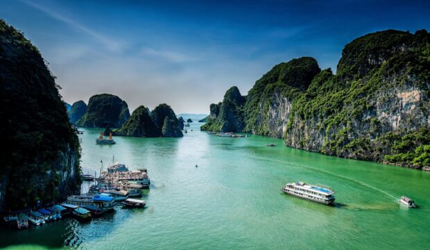 Scenic view of Halong Bay with numerous limestone islands and boats in clear water
