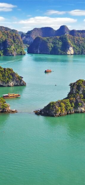 Scenic Halong Bay landscape with limestone islands and traditional boats on clear water