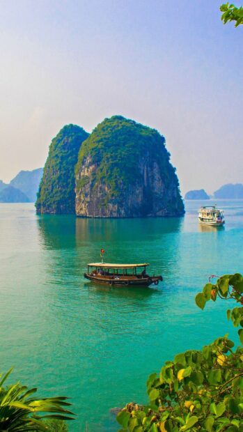 A scenic view of Halong Bay with green islands and traditional boats on turquoise water