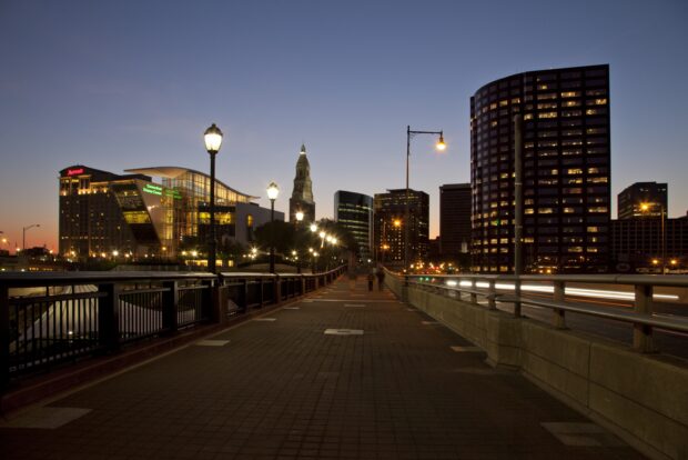 A beautiful Hartford skyline featuring tall buildings and street lamps at dusk with clear evening sky