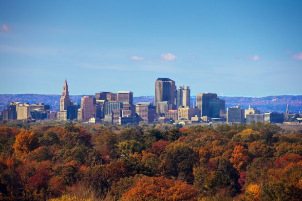 Hartford skyline with autumn trees in vibrant colors under a clear blue sky