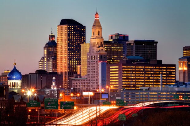 Hartford skyline with illuminated buildings and busy highway at dusk in HD quality