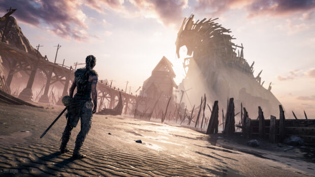 A warrior stands near an ancient bridge with a massive wooden horse structure in the distance in Hellblade Wallpapers