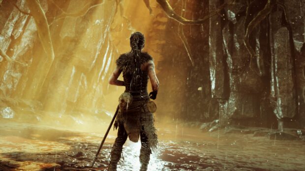 A Hellblade character stands in a mysterious cave with glowing light and wet ground, 4K Desktop Wallpaper