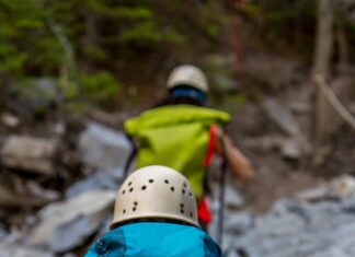 Hiker with a blue backpack climbing a rocky trail during a hiking adventure