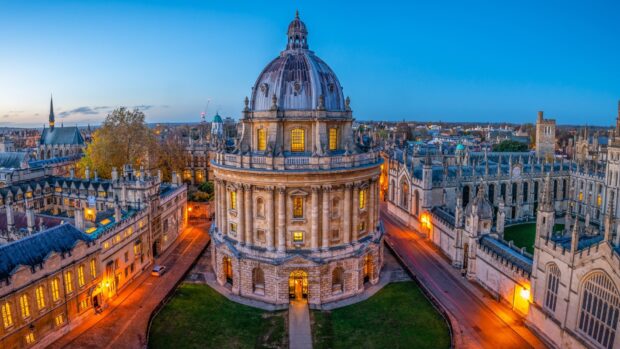 The historic architecture of Oxford University glows at dusk with clear skies and lit windows, HD Desktop Wallpaper