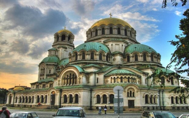 The image shows historic architecture with green domes and gold crosses in Bulgaria, 2K Desktop Wallpaper
