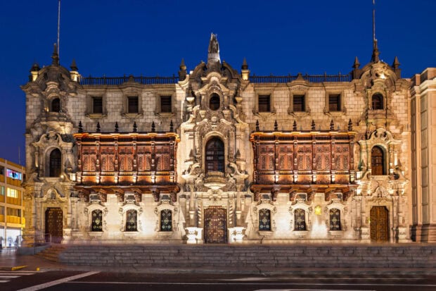 The historic building with ornate windows and balconies is illuminated in Lima Peru, 2K Desktop Wallpaper
