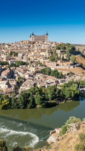 A historic cityscape in Spain with a river flowing and a castle on a hill in the background, HD Phone Wallpaper