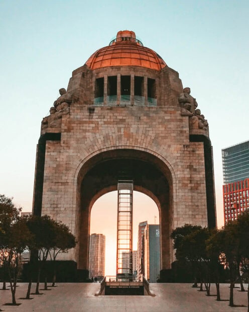 The historic monument in Mexico City is captured with buildings and trees around, HD Mobile Wallpaper