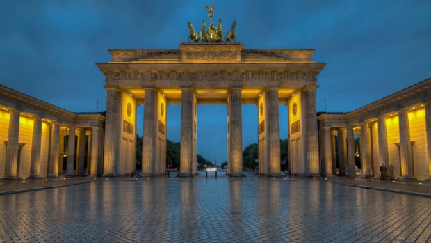 Historic Brandenburg Gate with illuminated columns at dusk in Berlin Germany
