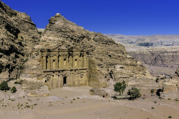 Ancient Petra architecture carved into sandstone cliffs in a desert landscape
